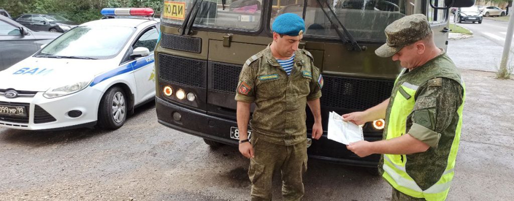 Инспектор ДПС ВАИ проверяет документы у водителя автобуса.